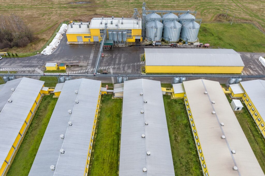 aerial panoramic view over silos and agro-industrial livestock complex on agro-processing plant